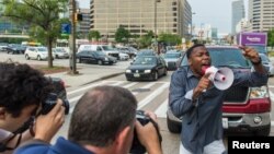 A demonstrator blocks traffic as protests moved into the street on the first day of pretrial motions for six police officers charged in connection with the death of Freddie Gray in Baltimore, Maryland, Sept. 2, 2015.