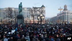 People gather to honor the victims of Sunday's fire in a shopping mall in the Siberian city of Kemerovo, in the center of Moscow, March 27, 2018. Several Russian cities including Moscow are holding rallies to commemorate the dead. 