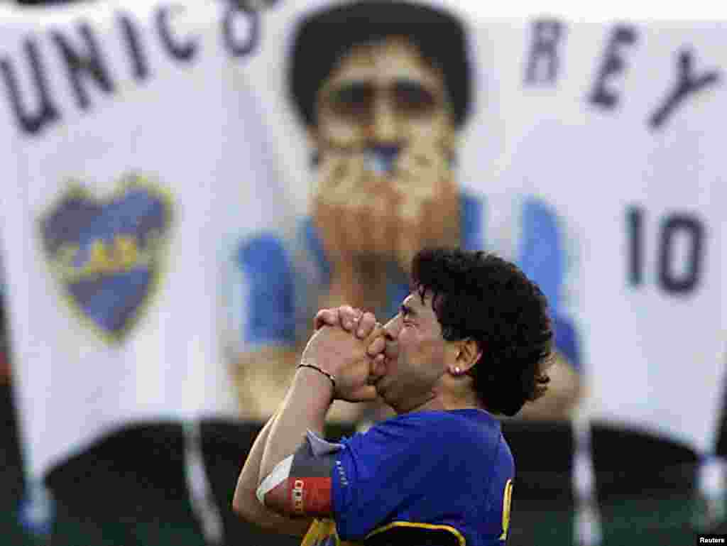 Lenda do futebol argentino, Diego Armando Maradona, vestindo uma camisa do Boca Juniors, agradece aos mais de 50.000 fãs que assistiram ao seu jogo de despedida no estádio do Boca Juniors em Buenos Aires, 10 de novembro de 2001 
