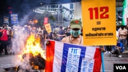 A monarchy reform protester holds up a sign to abolish the 112 Law, that criminalizes criticism of the Thai Monarchy with up to 15 years in prison, Bangkok, Thailand, Nov. 14, 2021 (VOA/Tommy Walker)