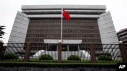 FILE - A Chinese national flag flutters in front of the Shanghai's No. 1 People's Intermediate Court in Shanghai, China.