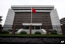 FILE - A Chinese national flag flutters in front of the Shanghai's No. 1 People's Intermediate Court in Shanghai, China.