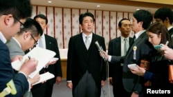 Thủ tướng Nhật Bản Shinzo Abe (giữa) nói chuyện với phóng viên báo chí sau khi viếng đền thờ Yasukuni