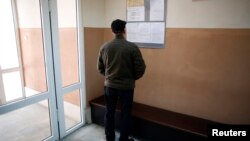 A man looks at a list with job vacancies posted at the entrance of an employment agency in the town of Vratsa, some 110km (68 miles) north of Sofia, Apr. 10, 2013. 