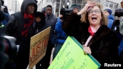 Supporters of the late Michael Brown confront Pattie Canter, right, who backs police officer Darren Wilson, in a street demonstration in Clayton, Missouri, Nov. 17, 2014.