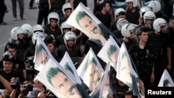 FILE - Demonstrators hold flags with pictures of imprisoned Kurdish rebel leader Abdullah Ocalan, during a protest against latest security operations in Diyarbakir, Turkey, Sept. 6, 2015.