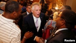 FILE - Terry McAuliffe, who was then Virginia's governor, greets the crowd while campaigning for his lieutenant governor, Ralph Northam, who was running to replace him, during a rally in Norfolk, Va., Nov. 6, 2017. Northam won the election.