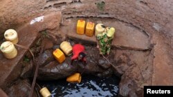 FILE - A woman fetches water from a well near Marsabit in northern Kenya, Sept. 16, 2014. A Kenyan university student from Marsabit County has won a grant to help track expectant mothers in the area.