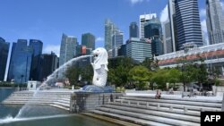 A man rests along Merlion park in Singapore on May 15, 2020. (Photo by Roslan RAHMAN / AFP)