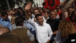 FILE - Zoran Zaev, center, the leader of the opposition social democrats, waves to the supporters during a protest in front of the Government building in Skopje, Macedonia, May 17, 2015. 