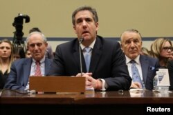 FILE - Michael Cohen, the former personal attorney of U.S. President Donald Trump, is flanked by his attorneys Lanny Davis, left, and Mike Monico as he testifies before a House oversight committee hearing on Capitol Hill in Washington, Feb. 27, 2019.