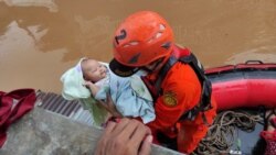 Personel Badan SAR Nasional (Basarnas) mengevakuasi bayi di daerah terdampak banjir di Jakarta, 20 Februari 2021. (Foto: Basarnas via REUTERS)