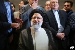 FILE- Iranian cleric Ebrahim Raisi registers his candidacy for the May 19 presidential elections at the Interior Ministry in Tehran, Iran, April 14, 2017.