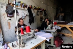 FILE - Palestinian workers sit during a power cut by Israel's electric company at a local company in the West Bank city of Nablus, Feb. 25, 2015.