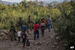 Venezolanos cruzan ilegalmente de regreso a su país después de comprar comida en La Parada cerca de Cúcuta, Colombia, el 5 de octubre de 2021.