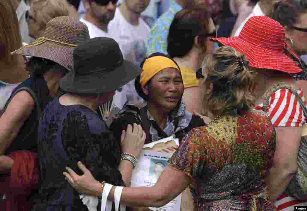 A woman is comforted as people attend a commemoration service for the 10th anniversary of the Bali bombing in Garuda Wisnu Kencana cultural park in Jimbaran, Bali, October 12, 2012.