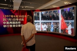 A visitor watches a video of the 1997 Hong Kong handover ceremony during an exhibition to celebrate the 20th anniversary of its handover to Chinese rule, at the National Museum of China in Beijing, June 27, 2017.