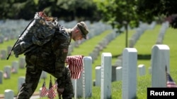 美国陆军第3步兵团的士兵在阿灵顿国家公墓的墓碑前插国旗 (2018年5月24日)