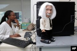 FILE - A staff member of Hanson Robotics checks on a Professor Einstein educational robot in Hong Kong, Sept. 28, 2017.