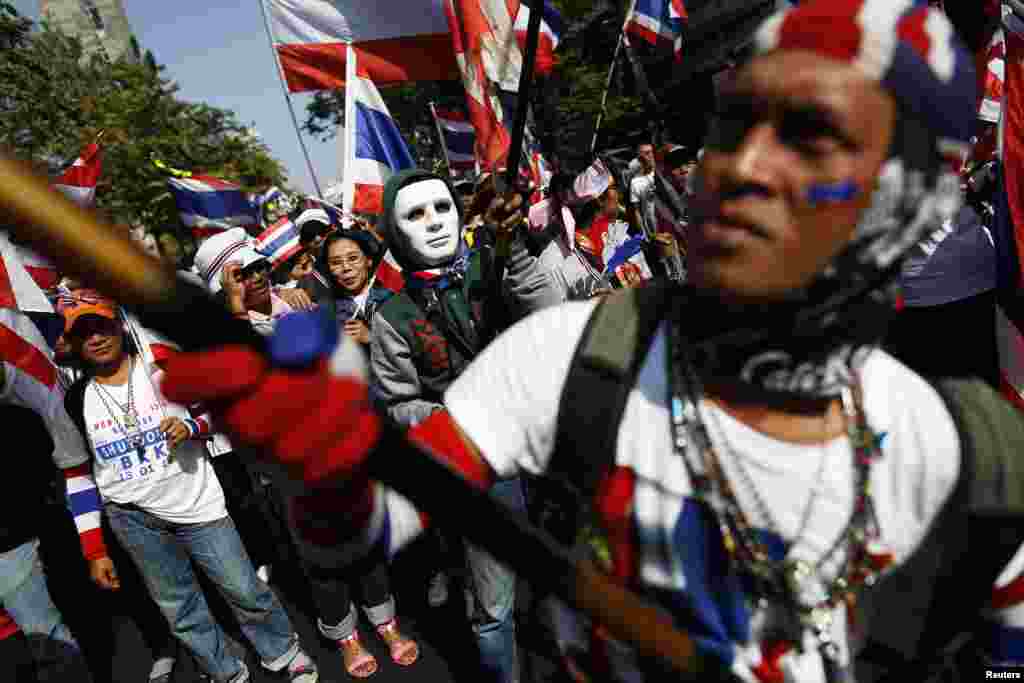 Demonstran anti pemerintah melambaikan bendera selagi berjalan menuju distrik keuangan Bangkok, 21 Januari 2014. 