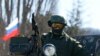 一名据信是俄军士兵的军人守卫在克里米亚首府辛菲罗波尔城外一处乌克兰军事驻地外。（2014年3月3日）