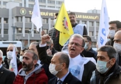 FILE - Protesters shout slogans during a demonstration against hikes in the price of consumers' electricity and gas bills in front of the Ministry of Energy in Ankara, Jan. 6, 2022.