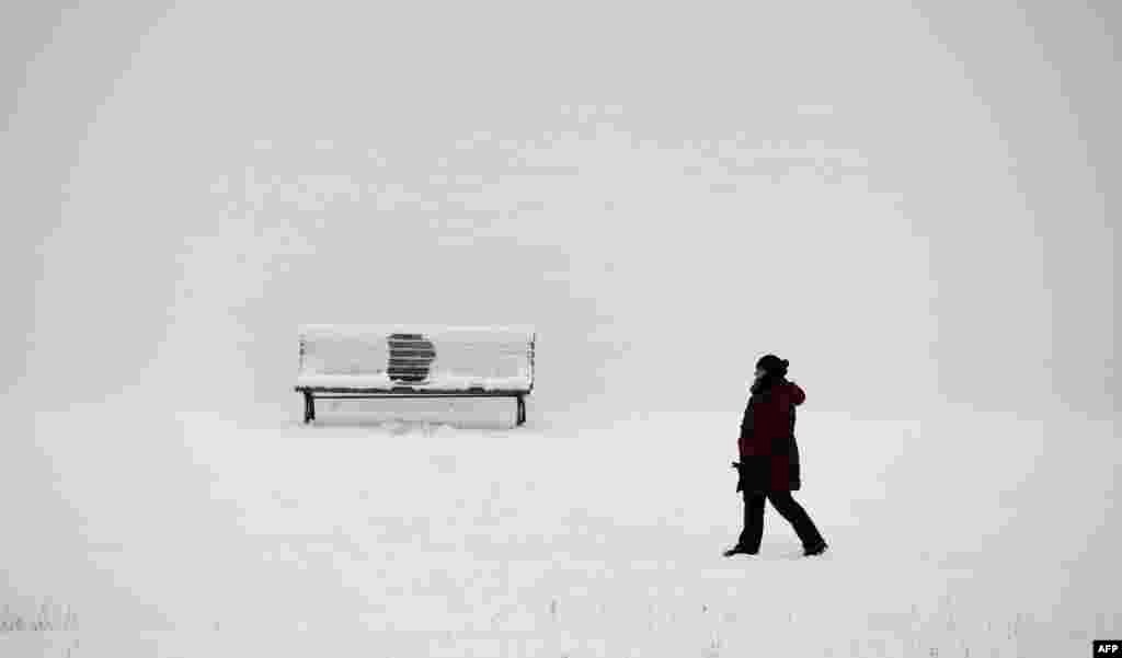 A woman takes a walk along the river Spree on a cold winter day in Berlin, Germany.