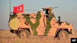 FILE - A Turkish military vehicle is seen on the outskirts of the Syrian town of Manbij, Nov. 1, 2018.