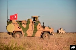 FILE - Turkish and U.S. troops conduct joint patrols around the Syrian town of Manbij, as part of an agreement that aimed to ease tensions between the two NATO allies, Nov. 1, 2018.