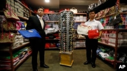 FILE - Hong Kong Customs Divisional Commander of Intellectual Property Transnational Investigation Cheuk Tak-wai, left, and Police Assistant Divisional Commander of Operations Ho Siu-tung show suspected counterfeit products during a press conference in 2015. (AP Photo/Kin Cheung)