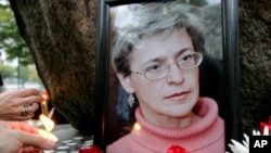 People light candles next to a portrait of Russian journalist Anna Politkovskaya during a rally in St. Petersburg (File 2006)