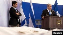 Israel's PM Benjamin Netanyahu (R) delivers a speech near the covered bodies of victims of Friday's attack on a Paris grocery, during their joint funeral in Jerusalem, Jan. 13, 2015. 