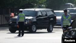 FILE - A motorcade leaves the U.S. Embassy after U.S. officials had trade talks with Chinese counterparts, in Beijing, China, May 4, 2018. 