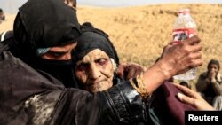 Displaced Iraqi women who just fled their home,rest in the desert as they wait to be transported while Iraqi forces battle with Islamic State militants in western Mosul, Iraq February 27, 2017.