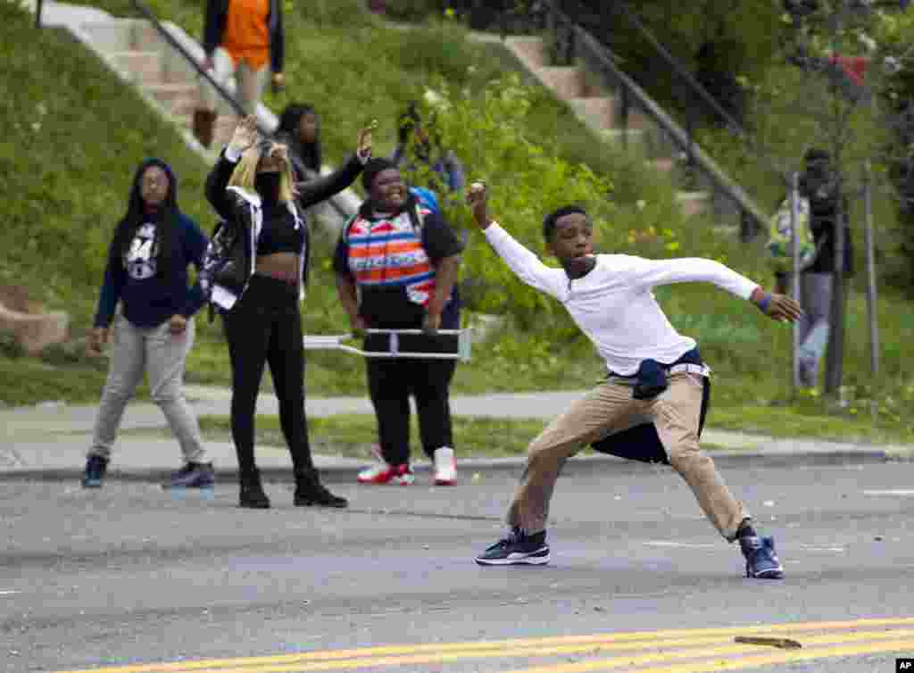 Manifestantes atiram pedras contra a polícia após o funeral de&nbsp;Freddie Gray, Abril 27, 2015, na igreja Baptista de New Shiloh em Baltimore.