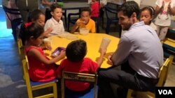 Samuel Díaz, uno de los cofundadores de 'Nutriendo El Futuro', conversa con alguno de los niños mientras cenan. Foto: Luisana Solano - VOA.