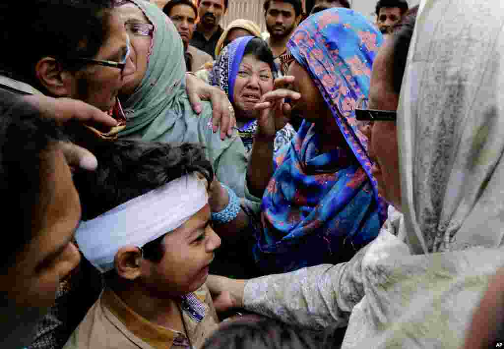 Eric John (bawah) yang selamat dari serangan bom hari Minggu, menangis dalam upacara pemakaman sepupunya yang tewas di Lahore, Pakistan (28/3). (AP/K.M. Chaudary)