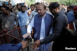 FILE - Former Prime Minister Nawaz Sharif arrives to the district High Court ahead of a hearing on treason allegations, in Lahore, Pakistan, Oct. 8, 2018.