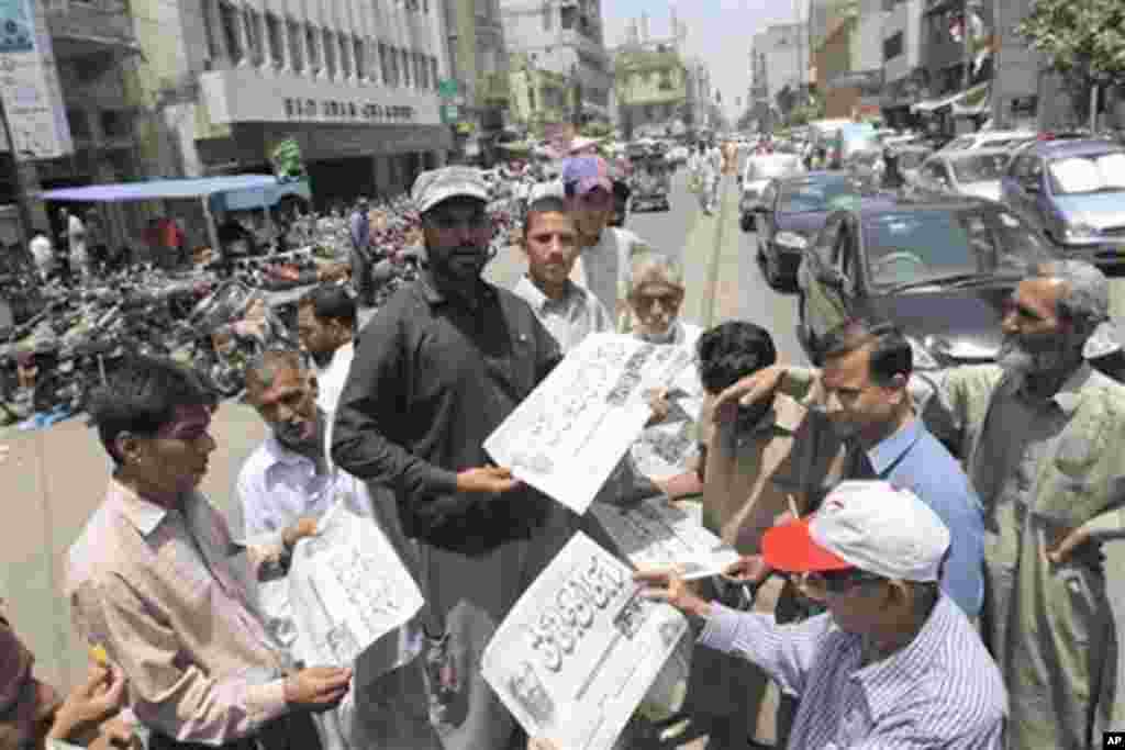 People buy newspapers reporting the killing of Al-Qaida leader Osama bin Laden in Pakistan, at local newspaper printing press in Karachi, Pakistan Monday, May 2, 2011.