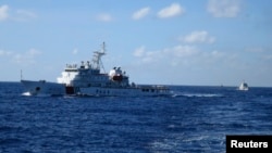 Kapal China mengejar kapal Vietnam, tidak terlihat di foto, setelah mendekati kilang minyak China di Laut China Selatan, 15 Juli 2014.