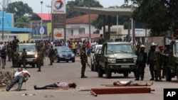 FILE - Bodies lie in the street as Congolese troops stand guard during election protests in Kinshasa, Democratic Republic of Congo, Sept. 19, 2016.