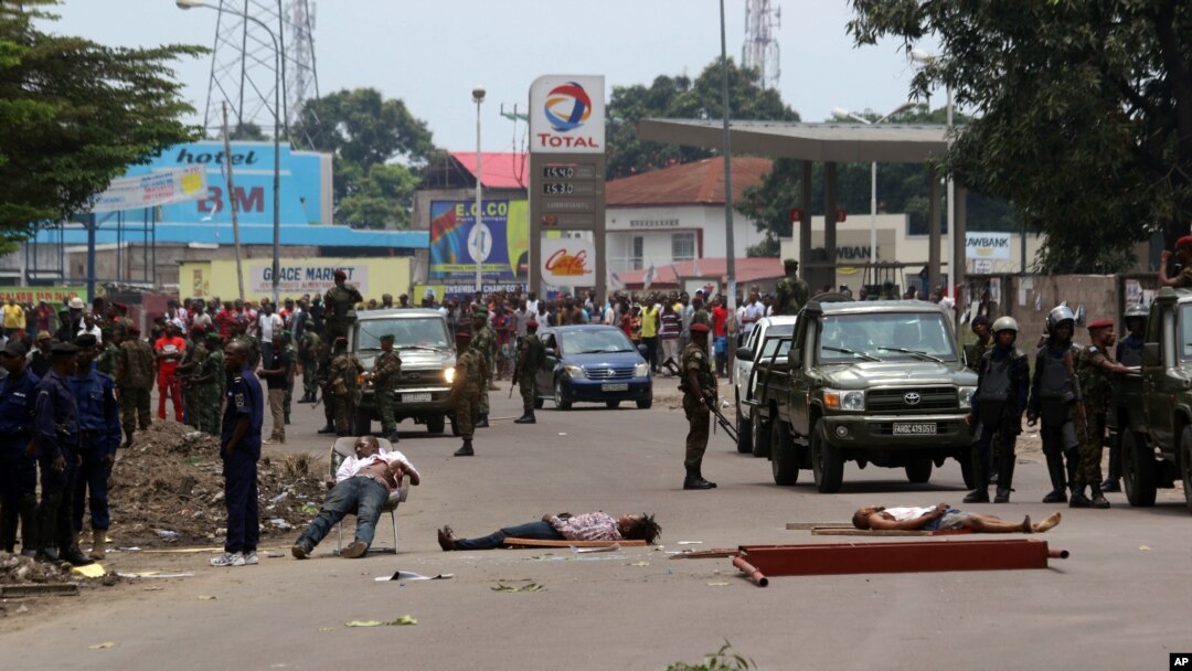 FILE - Bodies of people killed during election protests lie in the street as Congolese troops stand by in Kinshasa, Democratic Republic of Congo, Sept. 19, 2016. More than 50 people died during protests in September, according to rights groups and the United Nations.