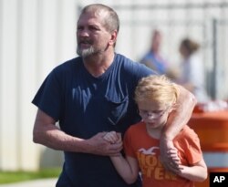 Joey Taylor walks with his daughter, Josie, after picking her up at Oakdale Baptist Church in Townville, S.C., Sept. 28, 2016. Students were evacuated to the church after a shooting at Townville Elementary School.