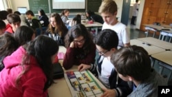 FILE - Students look at a World Cup sticker book during their Portuguese class, in Sao Paulo, Brazil, May 21, 2018.