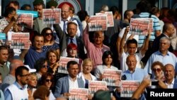 Lawmakers and press freedom activists hold copies of the Cumhuriyet newspaper during trial of 17 writers, executives and lawyers of the secularist Cumhuriyet newspaper in Silivri near Istanbul, Turkey, Sept. 11, 2017. 
