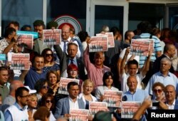 Lawmakers and press freedom activists hold copies of the Cumhuriyet newspaper during trial of 17 writers, executives and lawyers of the secularist Cumhuriyet newspaper in Silivri near Istanbul, Turkey, Sept. 11, 2017.