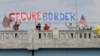 FILE - Demonstrators with signs on an overpass in Indianapolis, Indiana, protest against people who immigrate illegally.