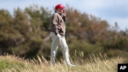 FILE - Republican presidential contender Donald Trump walks near the 16th green of his renovated golf course in Turnberry, Scotland, July 30, 2015. He plans to visit his Scottish golf properties for three days starting Thursday.