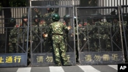 Paramilitary police officers arrange the steel fence at the Japanese Consulate General in Shanghai, September 19, 2012.