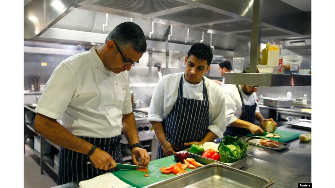 Chef Atul Kochhar (L) slices tomatoes at his Benares restaurant in Mayfair, central London, Jan. 21, 2015.